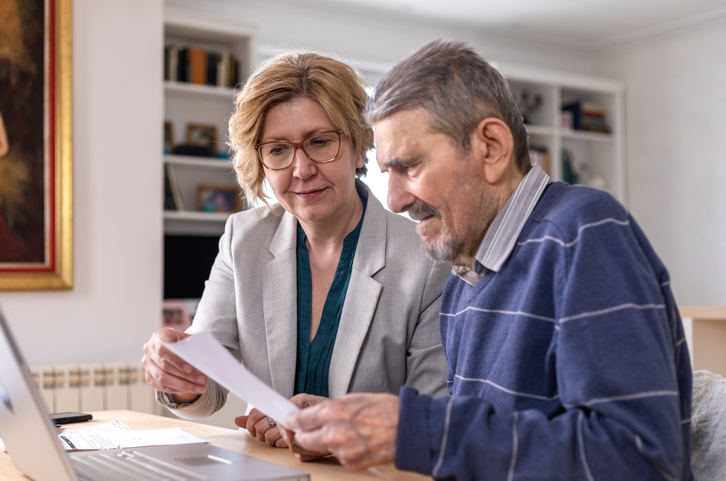 A senior couple reviews documentation for a will.