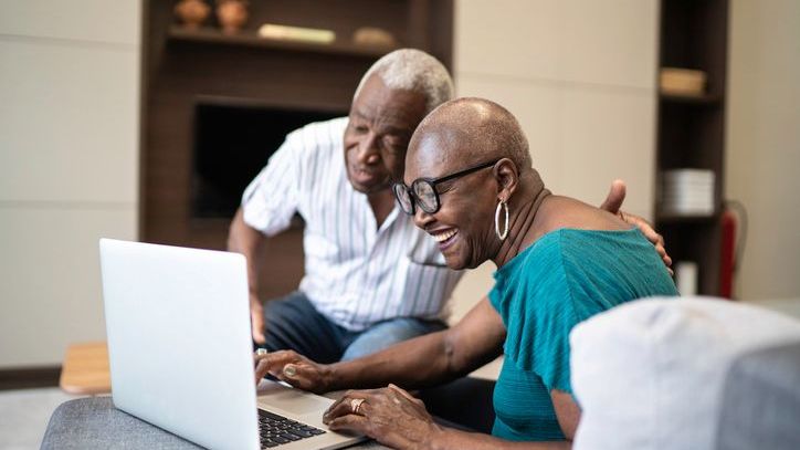 A retired couple in their 70s reviews their investment portfolio.