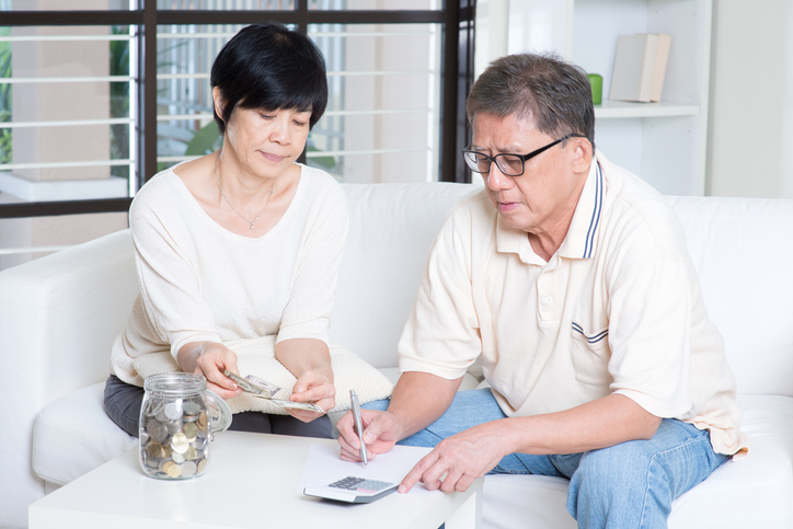 A senior couple estimating how much they should withdraw from their retirement accounts each year with the 4% rule.