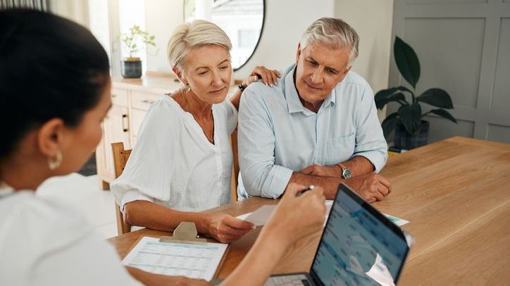 A woman and her husband meet with their financial advisor to discuss their plan for retirement.