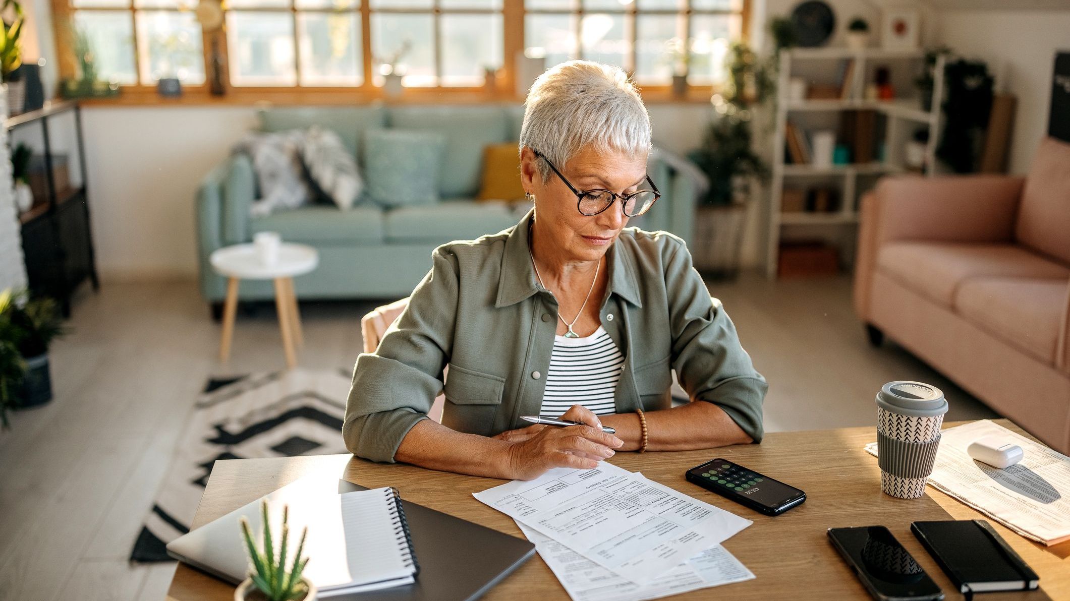 A woman reviews her projected expenses in retirement to determine whether she can afford to retire at age 65.