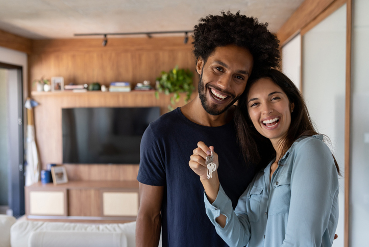 A couple celebrating their home purchase after qualifying for a low mortgage rate.