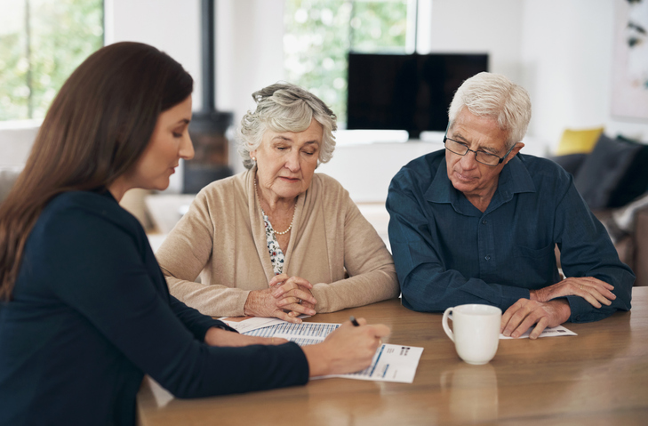 A senior couple meeting with a financial advisor to create an estate plan to avoid probate in Missouri.