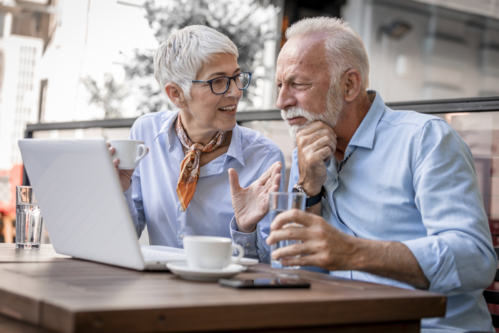 A senior couple reviewing their pension maximization strategy that includes a life insurance option for a surviving spouse.