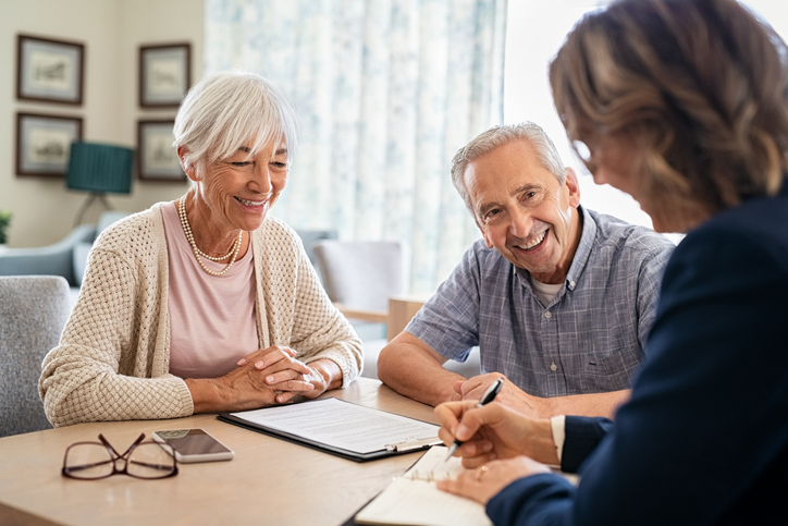A senior couple reviewing their retirement plan with a financial advisor to focus on long-term care.