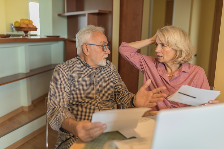 A senior couple comparing the costs of living for different retirement communities.