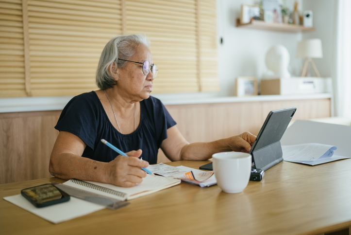 A senior calculating her cost of living for a retirement community.