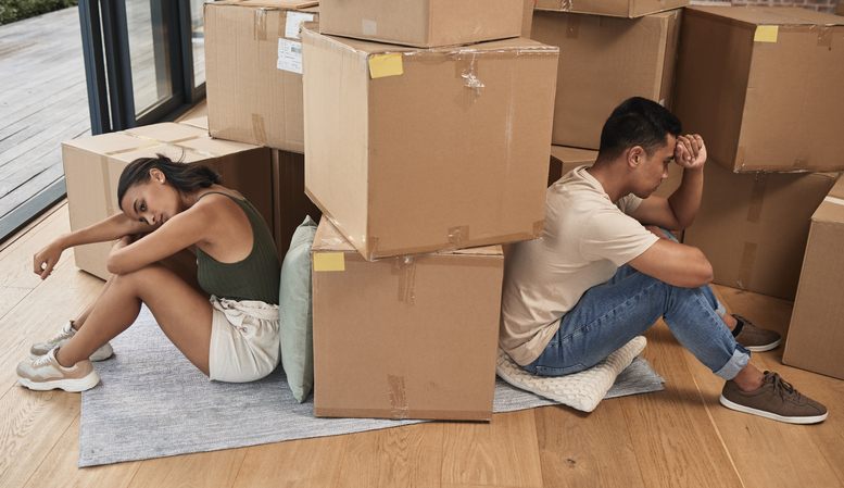 A divorcing couple moves boxes out of the home they shared. 