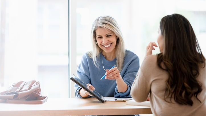 A financial advisor who has received a financial planning certificate meets with a client.