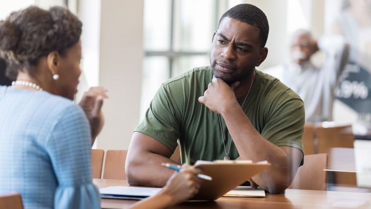 A member of the military speaks with a loan officer who's processing his VA loan application.