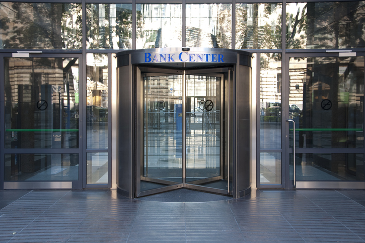 A revolving door that leads to the lobby of the headquarters of a regional bank.