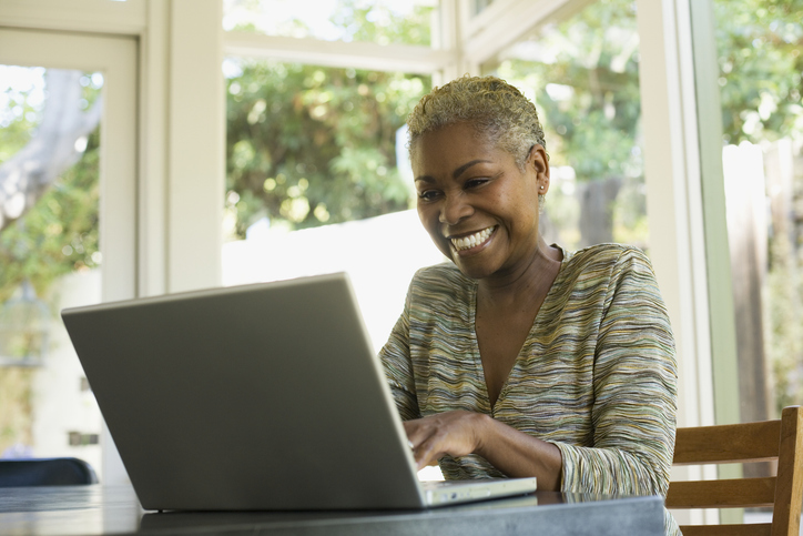 A woman making changes to her retirement plan after comparing her retirement savings with benchmarks for her age group.