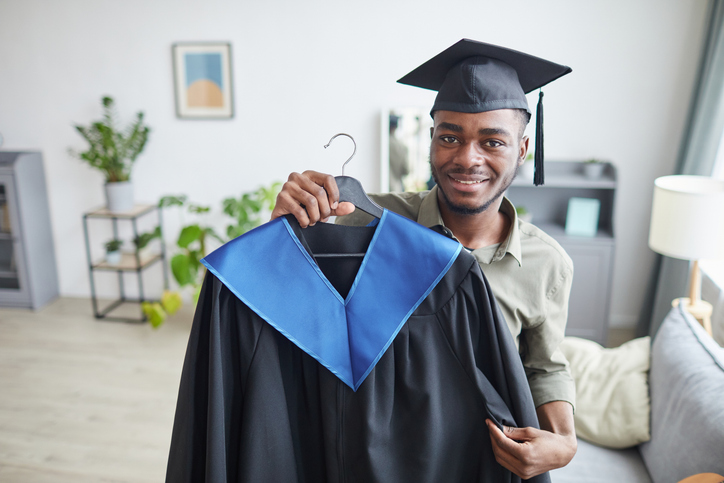 A college graduate holding graduation gown before the ceremony.