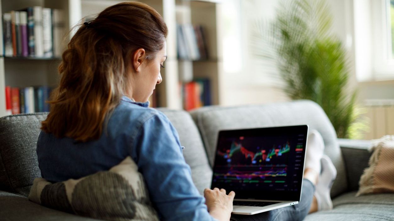 An investor monitors the price of a stock on her laptop. 