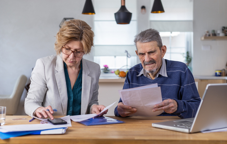 A husband and wife drafting power of attorney documents to close a bank account. 