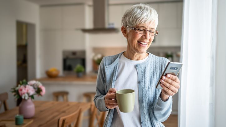 A woman who has both a qualified retirement account through her job and a Roth IRA looks over her retirement savings on her phone.