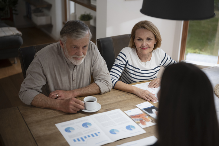 A senior couple discussing a power of attorney with their financial advisor in Kentucky.