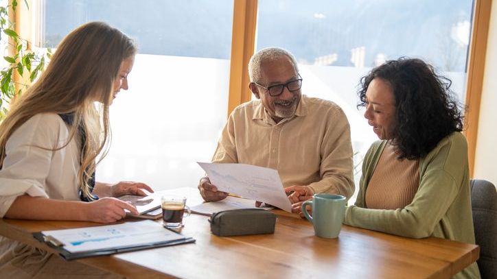 A retired couple meets with their retirement planner in her office.