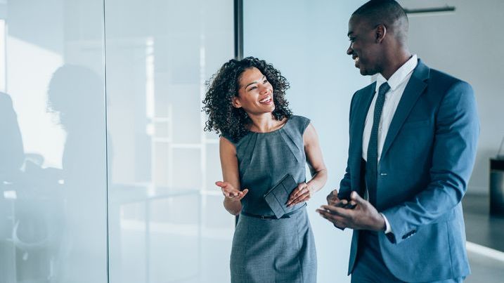 A pair of exempt reporting advisors talk on the way to a meeting in their office.