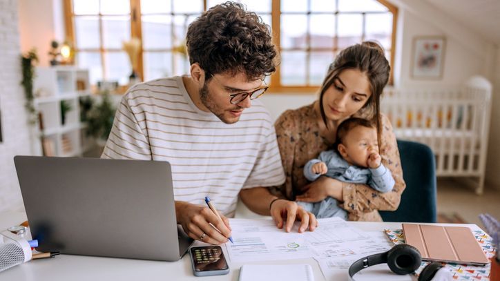 A young couple looks over some bills while reviewing their intermediate financial goals.