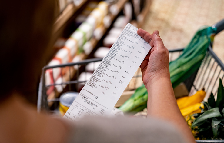 A shopper reviews grocery substitutions on their receipt, considering what the Chained CPI will show for inflation.