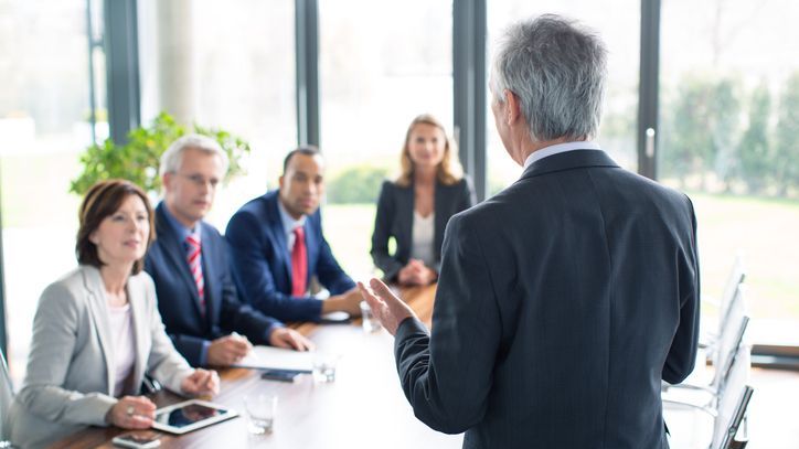 The CEO of a company gives a presentation before the company's corporate board of directors.