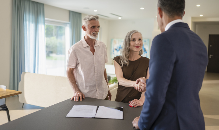 A couple meeting with a real estate broker to close on an investment.