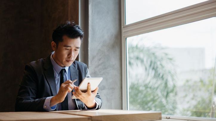 A real estate investor reviews his due diligence checklist on his tablet. 