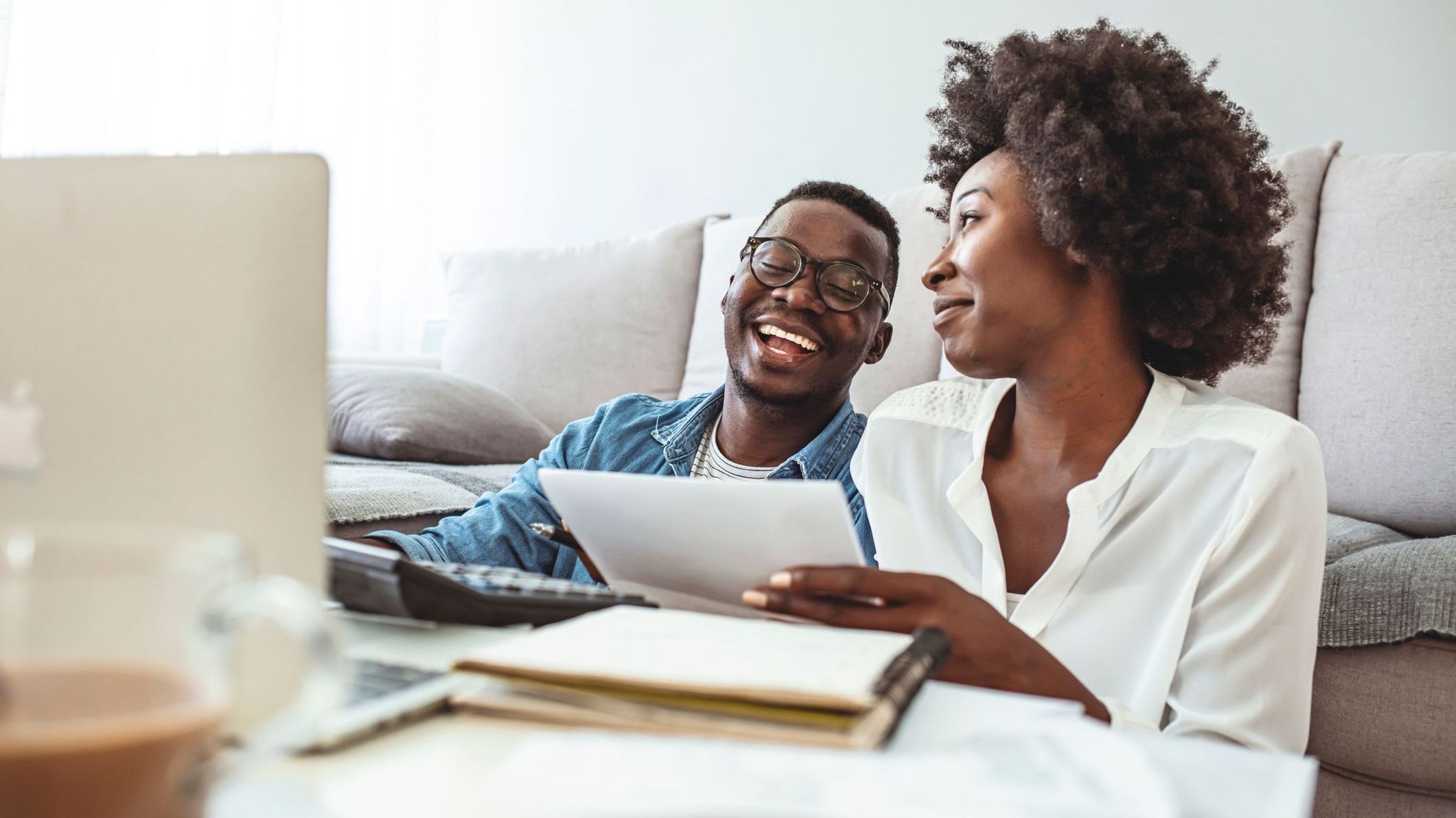 A newly married couple goes over their financial plan together in their living room.