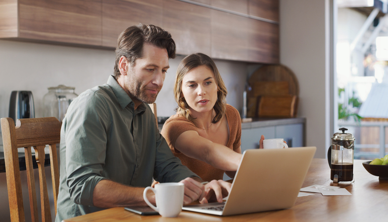 A couple researching strategies for consolidating debt.