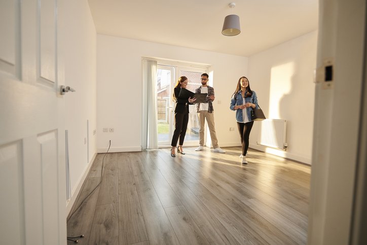 A real estate wholesaler shows a property to prospective buyers.