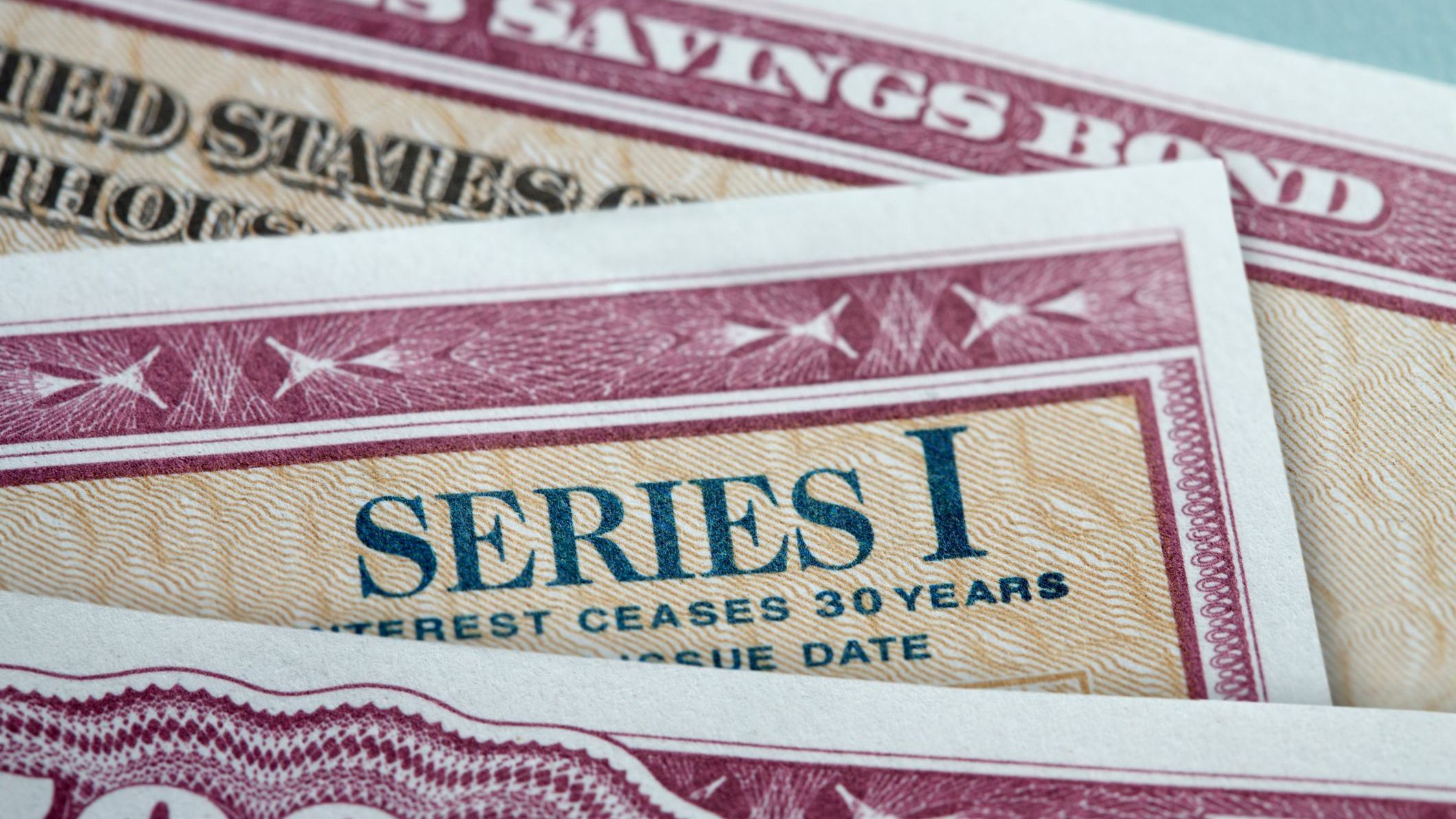 A close up of three U.S. government Series I Bonds stacked on top of each other.