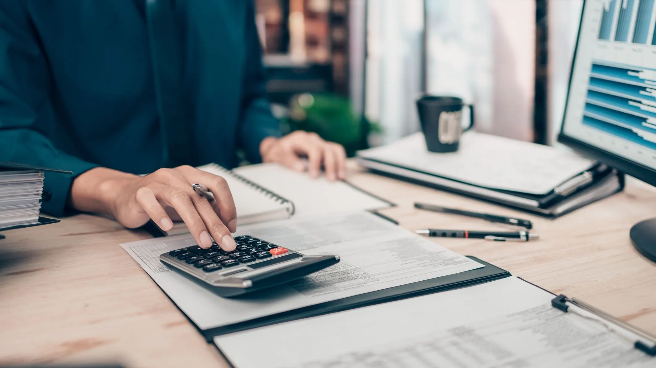 An investor adds up the value of his savings bonds on a calculator.