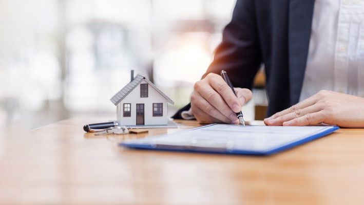 A loan officer signs off on mortgage documents.