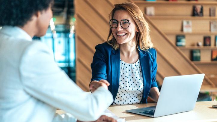 A real estate wholesaler shakes hands with an investor she recently completed a deal with.