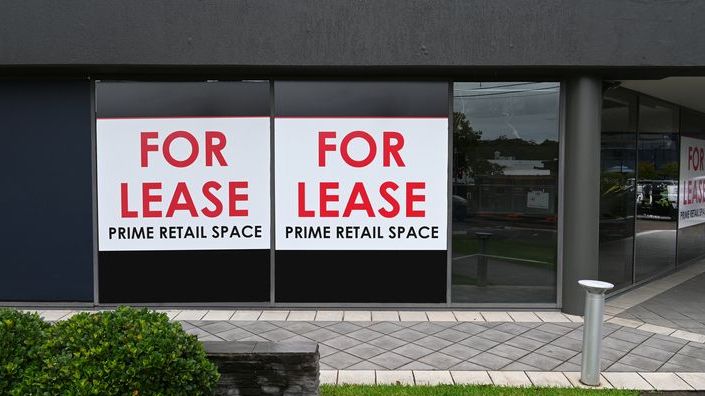 For lease signs hang in the windows of a commercial property. 