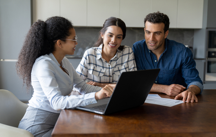 A couple meets with a financial advisor after reading some of the best books for personal investing. 