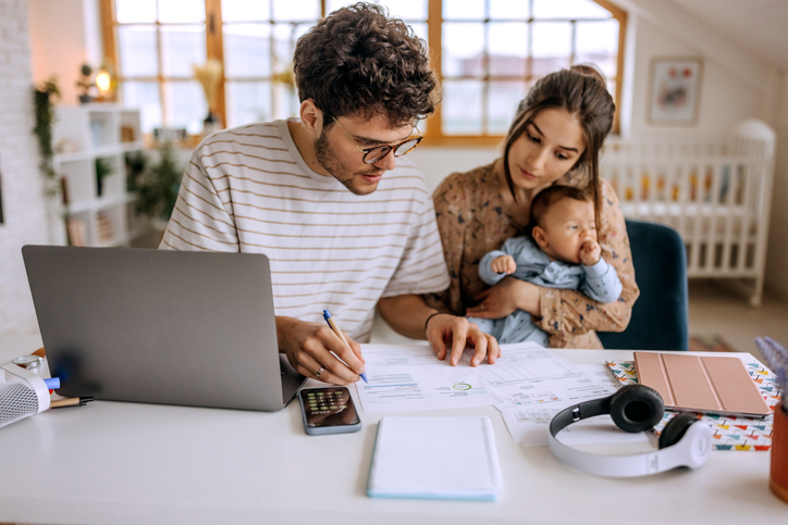 A young couple works on financial planning for 30 year olds, creating a college savings fund for their child. 