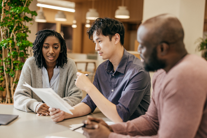 A couple filling a small estate affidavit form with an advisor.