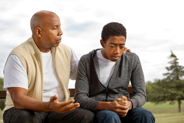 A parent discussing an estate plan with his child. 