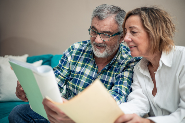 A senior couple reviewing data that suggests wealth has shifted from an earnings-based model toward an investment-based model. 