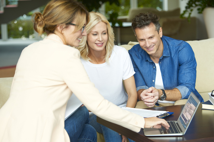 An advisor sits down with new clients, having used LinkedIn marketing to grow her firm's business. 