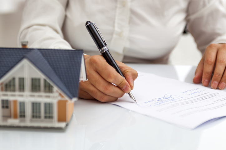 A real estate wholesaler signs paperwork for a deal he recently closed.