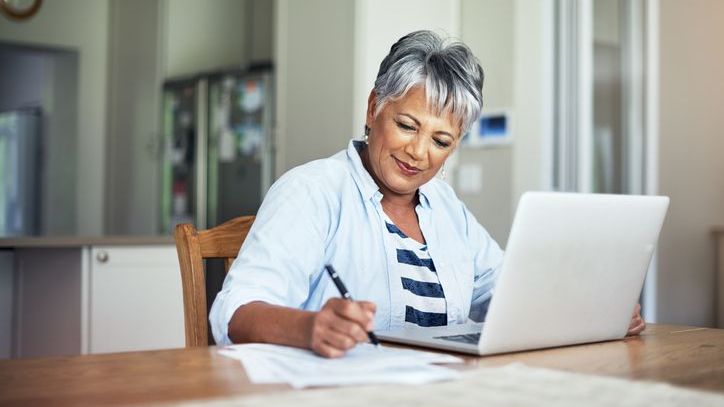 A woman works on her budget so she can direct more of her income to her retirement savings.