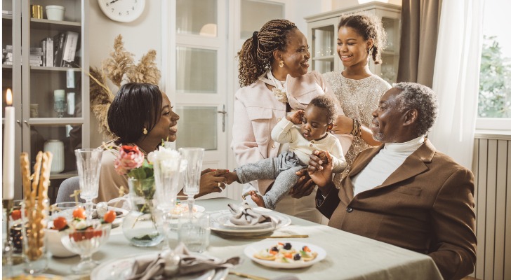 Three generations of a wealthy family sit around the dinner table.