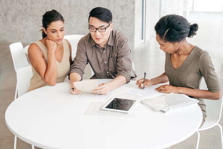 Clients meeting with a financial advisor to review a real estate portfolio.