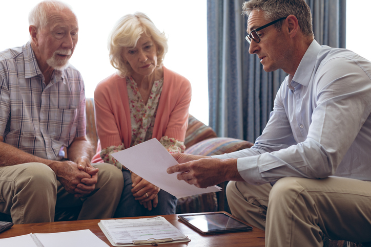 A senior couple reviewing their retirement accounts with an advisor.