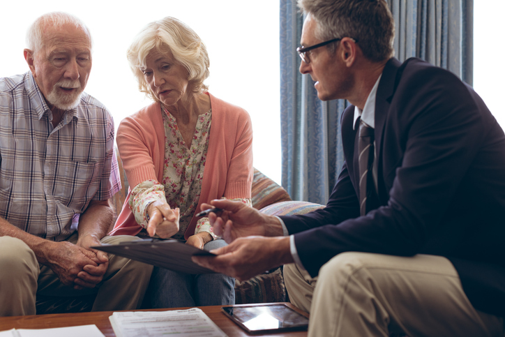 A senior couple discussing healthcare expenses with a financial advisor.