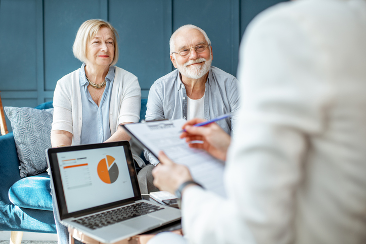 A senior couple meeting with a financial advisor to review their Roth IRA.