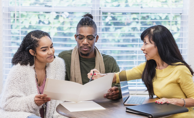 A couple reviewing their budget with a financial advisor.